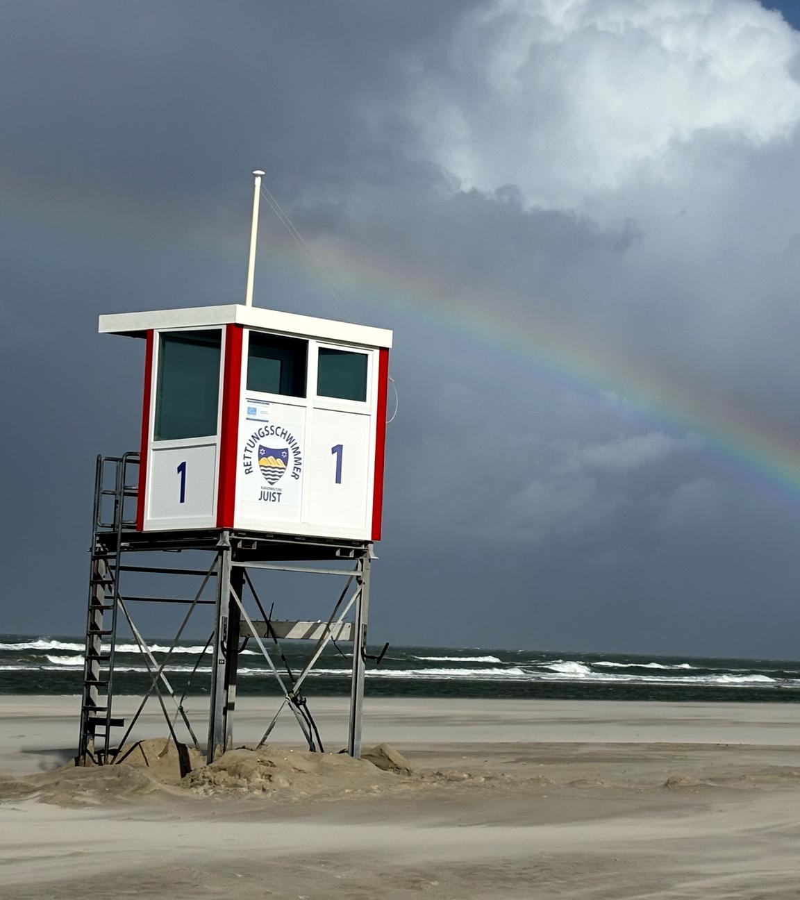 Ein Regenbogen steht an einem Himmel voll dunkler Wolken über der Nordsee und über der Insel Juist. Orkanartige Böen mit teils über 100 Kilometern pro Stunde ziehen über Teile von Norddeutschland. Dazu könne es Dauerregen sowie Gewitter geben, teilte der Deutsche Wetterdienst (DWD) mit.