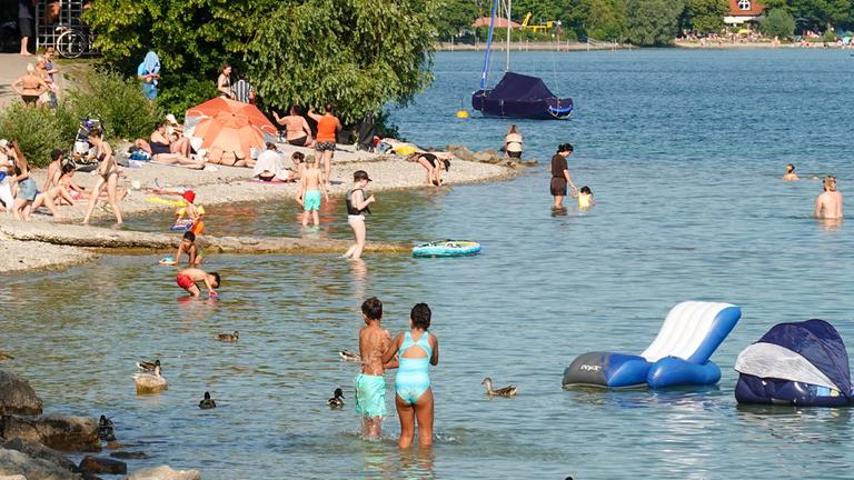 Familien verschaffen sich am 19.06.2026 bei hohen Temperaturen Abkühlung im Starnberger See.