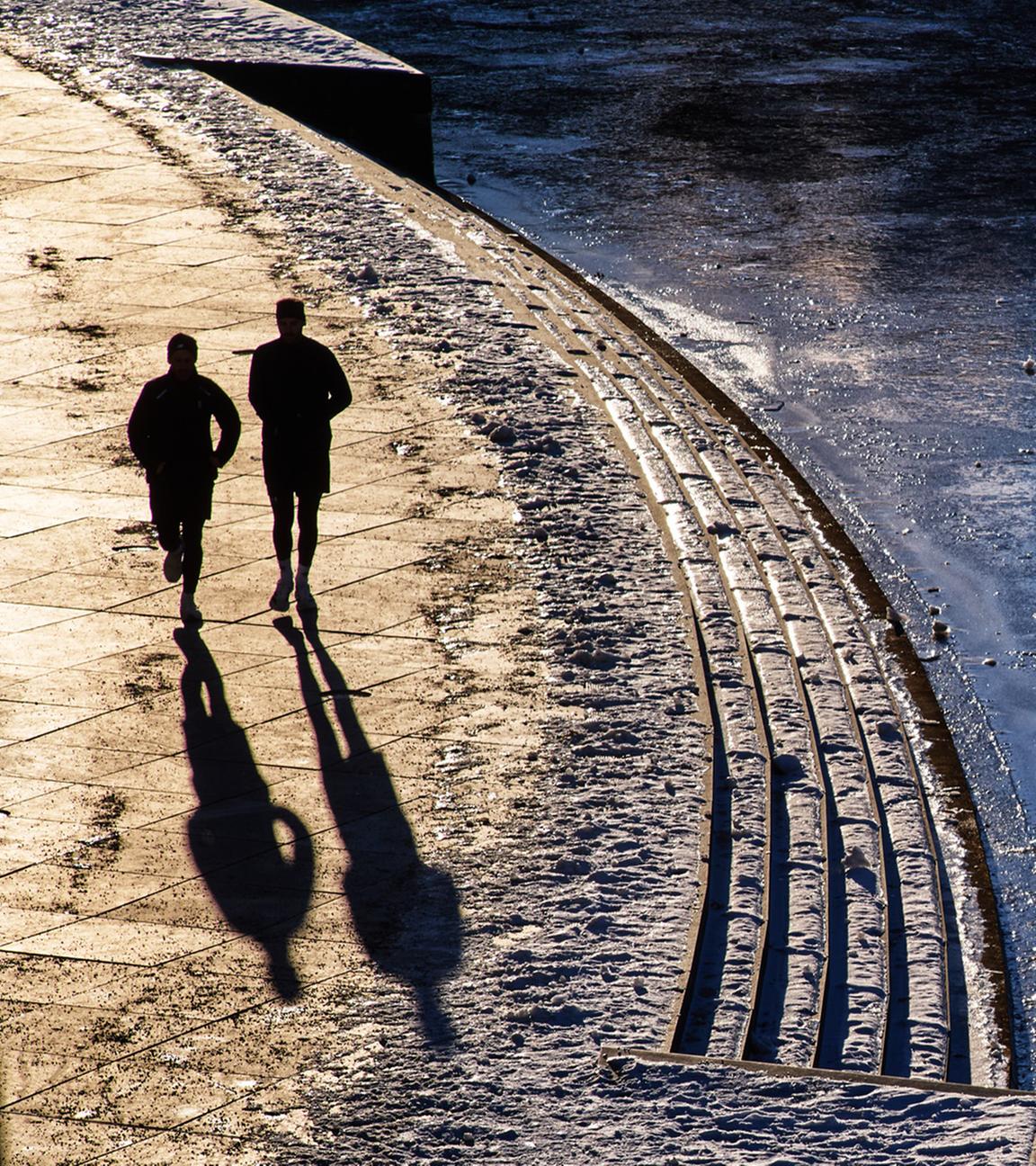 Zwei Personen Joggen entlang der gefrohrenen Spree am 11.01.2026 in Berlin.