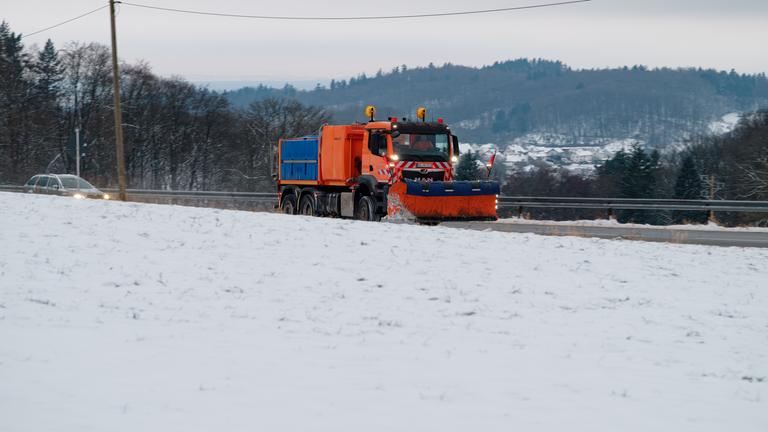 Ein Schneeräumfahrzeug fährt durch die schneebedeckte Landschaft des Odenwalds. 