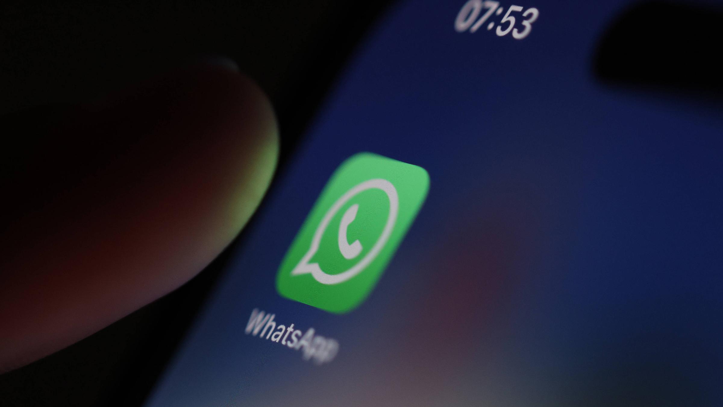 Das Logo des Instant-Messaging-Dienstes WhatsAppauf einem Smartphone, kurz bevor die App durch Fingertippen geöffnet wird. 