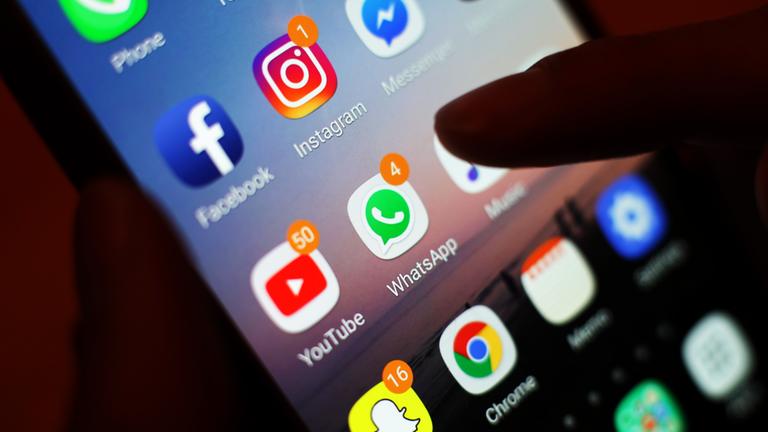 Die Symbole von Social-Media-Apps wie Facebook, Instagram, YouTube und WhatsApp sind auf dem Bildschirm eines Mobiltelefons zu sehen.