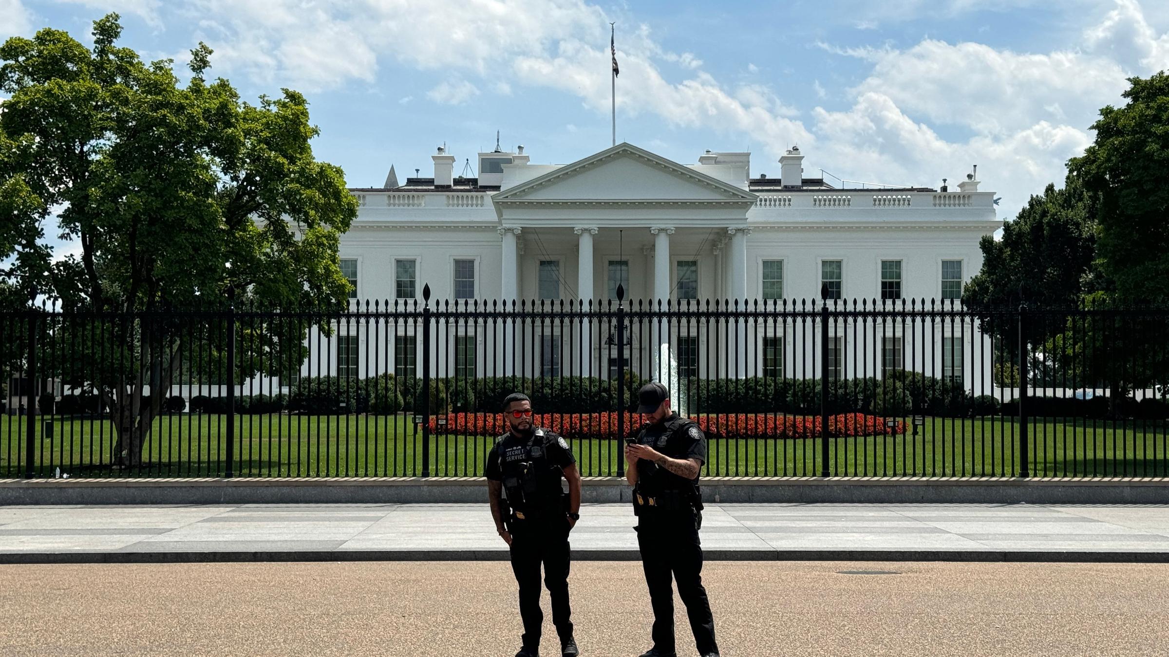 Zwei Beamte des Secret Service stehen vor dem Weißen Haus.
