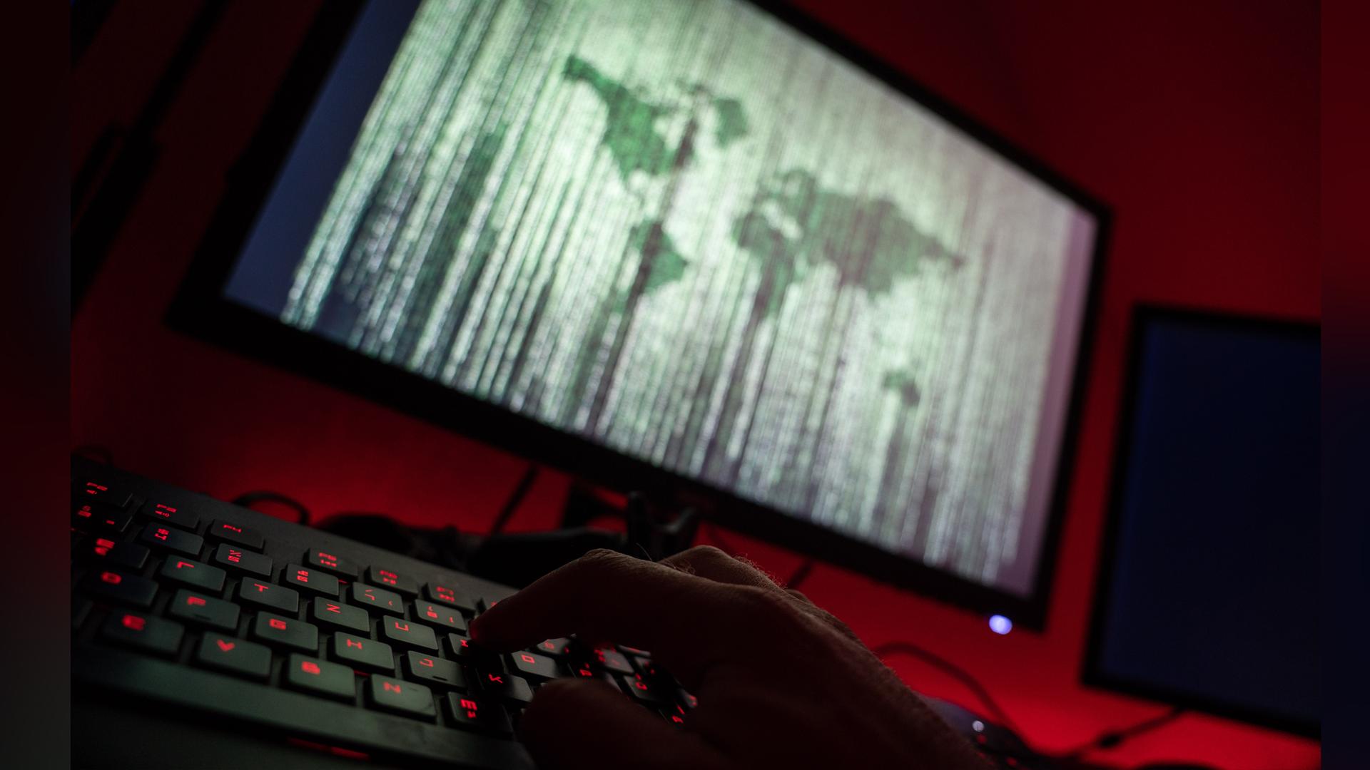 Ein Mann sitzt am Rechner und tippt auf einer Tastatur.