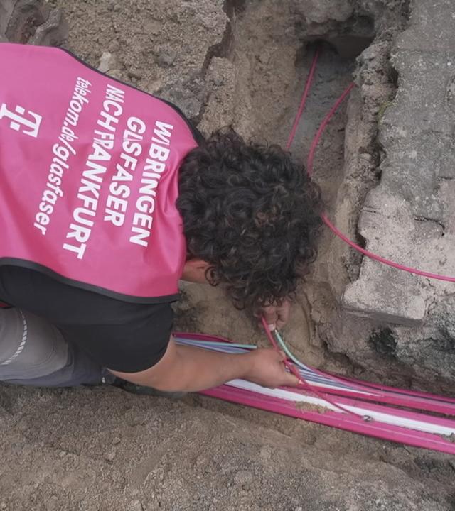Ein Mann installiert Glasfaser-Leitungen.