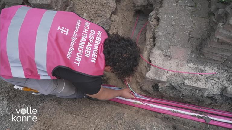 Ein Mann installiert Glasfaser-Leitungen.