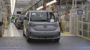 Man sieht ein VW Auto was in einer Poduktionshalle steht 