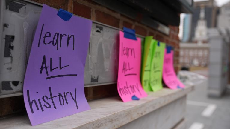Schilder und Poster mit der Aufschrift "learn all history".