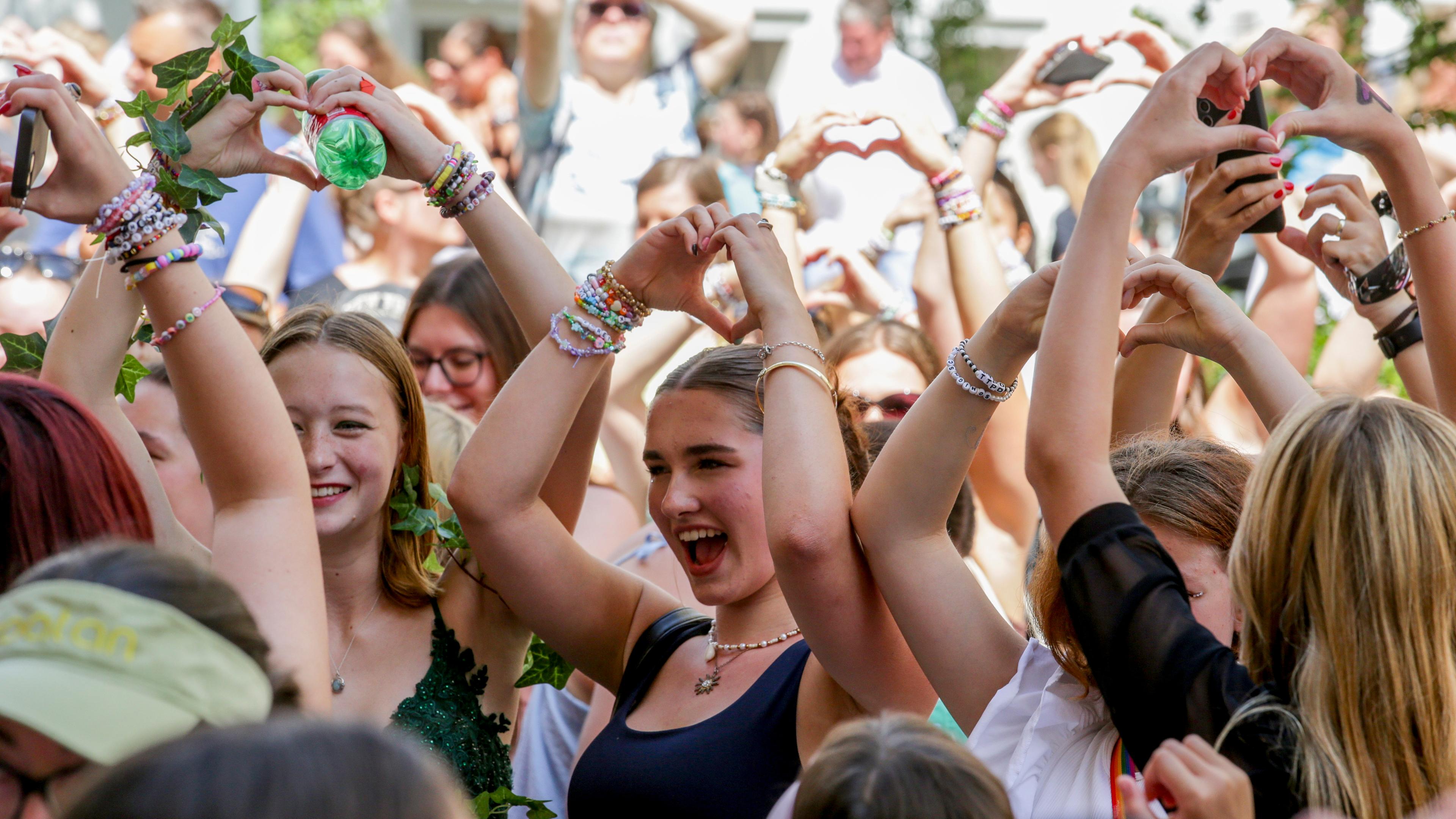 09.08.2024, Österreich, Wien: "Swifties" singen und tanzen in einer Wiener Straße.