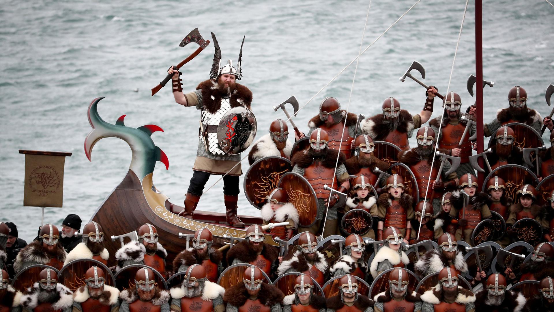 Mitglieder des Vereins "Jarl Squad", verkleidet als Wikinger, posieren für ein Gruppenfoto vor einer Galeere auf den Shetland-Inseln beim jährlichen Wikinger-Festival "Up Helly Aa"