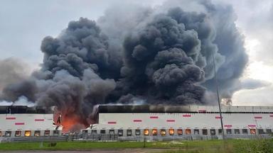 Rauch steigt über einem Wildberries-Logistikzentrum in Rjasan auf, während Feuerwehrleute nach einem ukrainischen Drohnenangriff den Brand löschen.