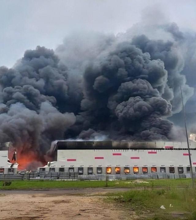 Rauch steigt über einem Wildberries-Logistikzentrum in Rjasan auf, während Feuerwehrleute nach einem ukrainischen Drohnenangriff den Brand löschen.