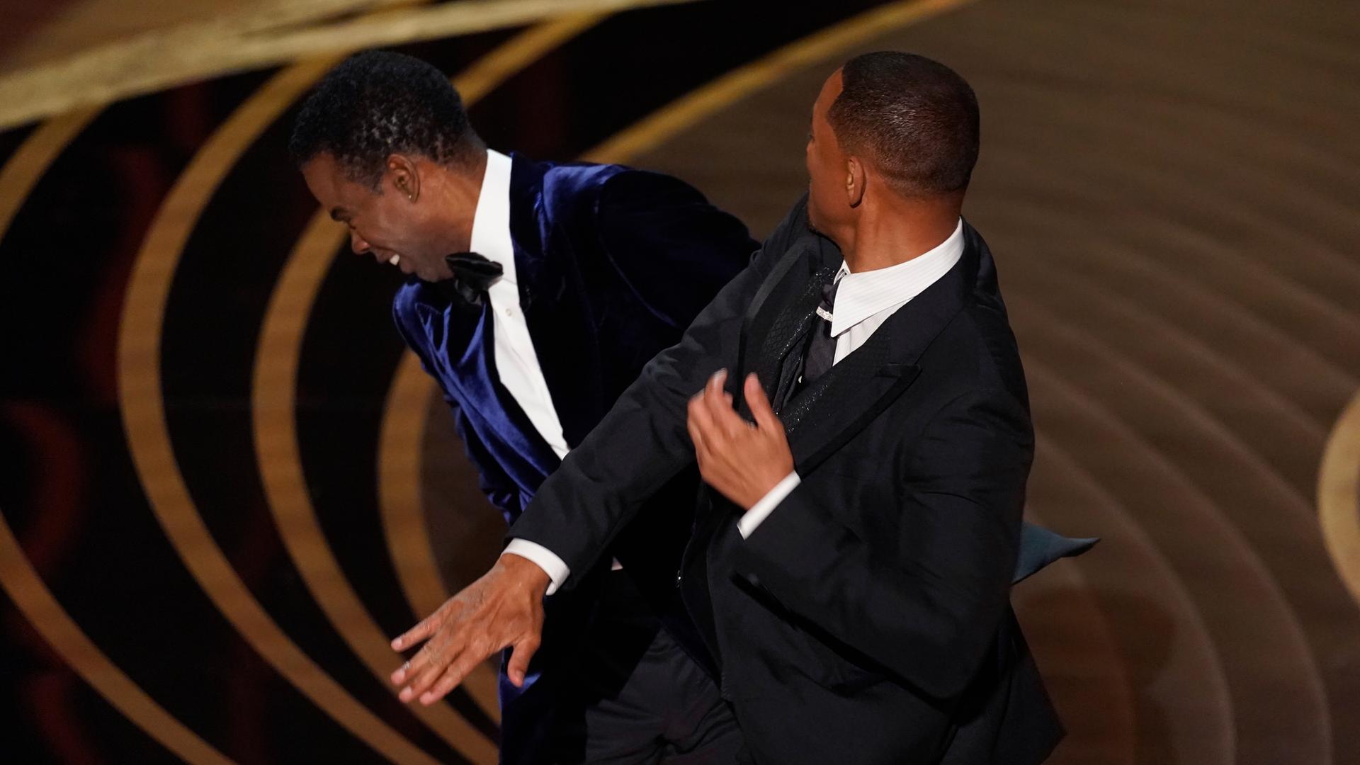 Schauspieler Will Smith gibt Komiker Chris Rock auf der Bühne der Oscar-Verleihung am 27. März 2022 eine Ohrfeige.