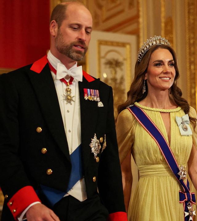 William und Kate betreten einen Raum in feierlicher Garderobe. 