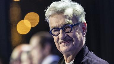 Wim Wenders, deutscher Regisseur, schaut in die Kamera. Er trägt eine runde dunkelblaue Brille.