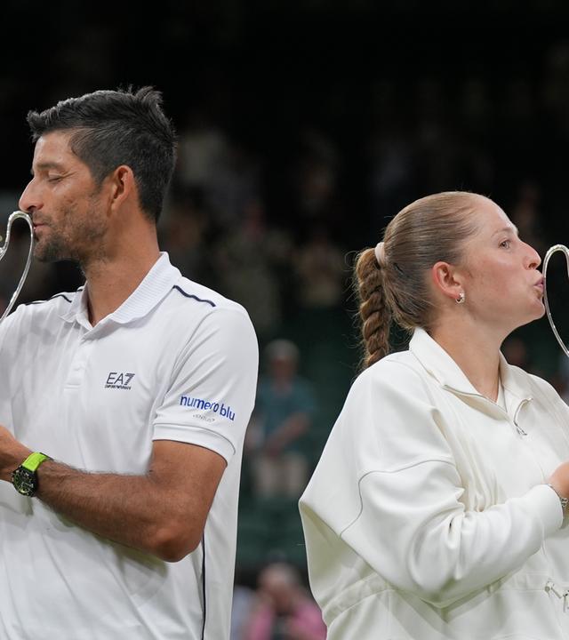 Jelena Ostapenko und Marcelo Arévalo küssen nach ihrem Sieg im Mixed-Doppelfinale von Wimbledon 2026 die Trophäe.