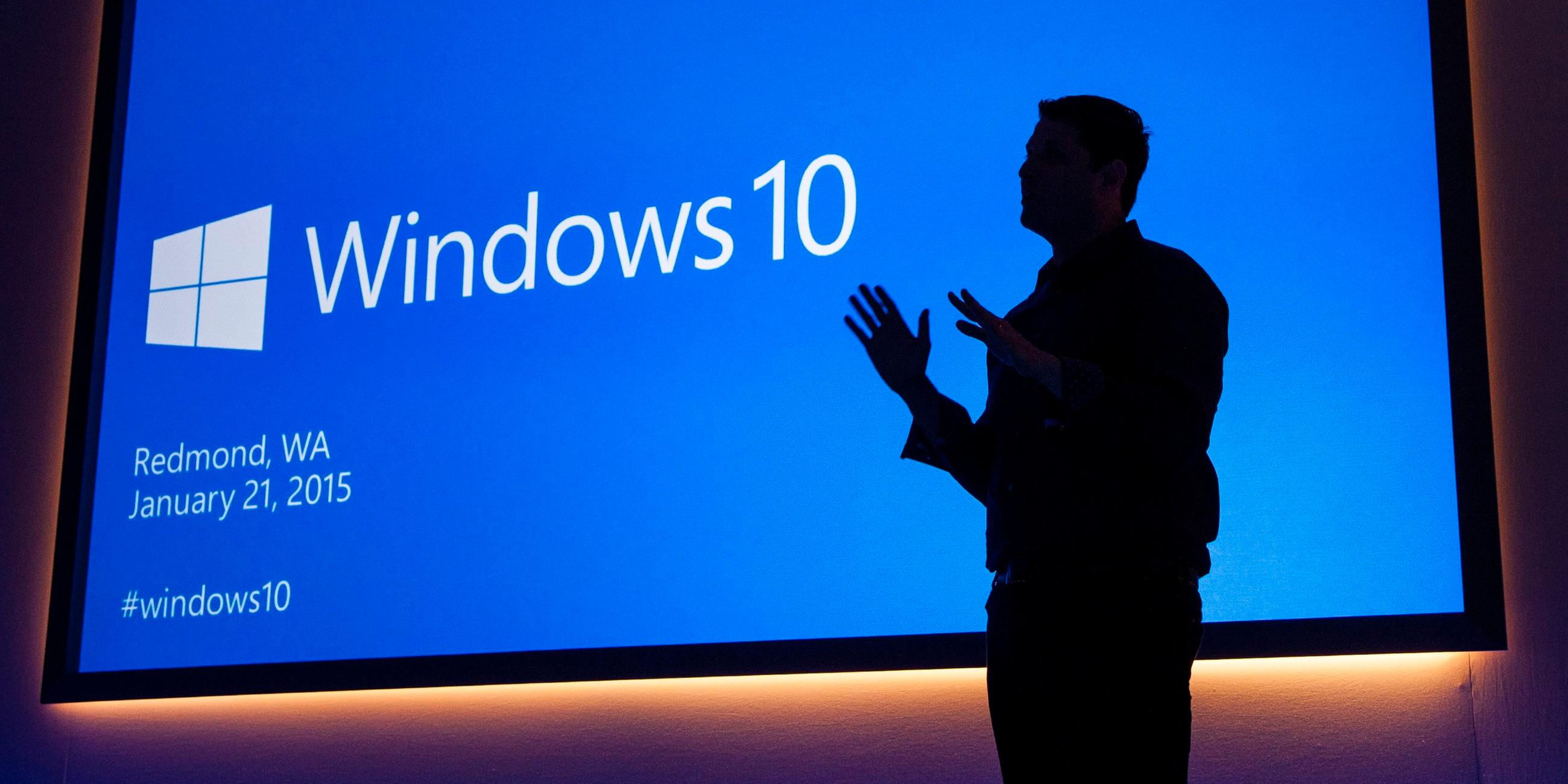 Microsoft Executive Vice President Terry Myerson beid er Präsentation von Windows 10 im Januar 2015. Man sieht nur seine Umrisse vor der blauen Präsentationsfolie.