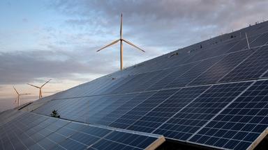 Windkraftanlagen stehen hinter Photovoltaikanlagen auf der Blocklanddeponie in Bremen.