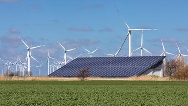 Landwirtschaftliches Gebäude mit Solardach und Windräder