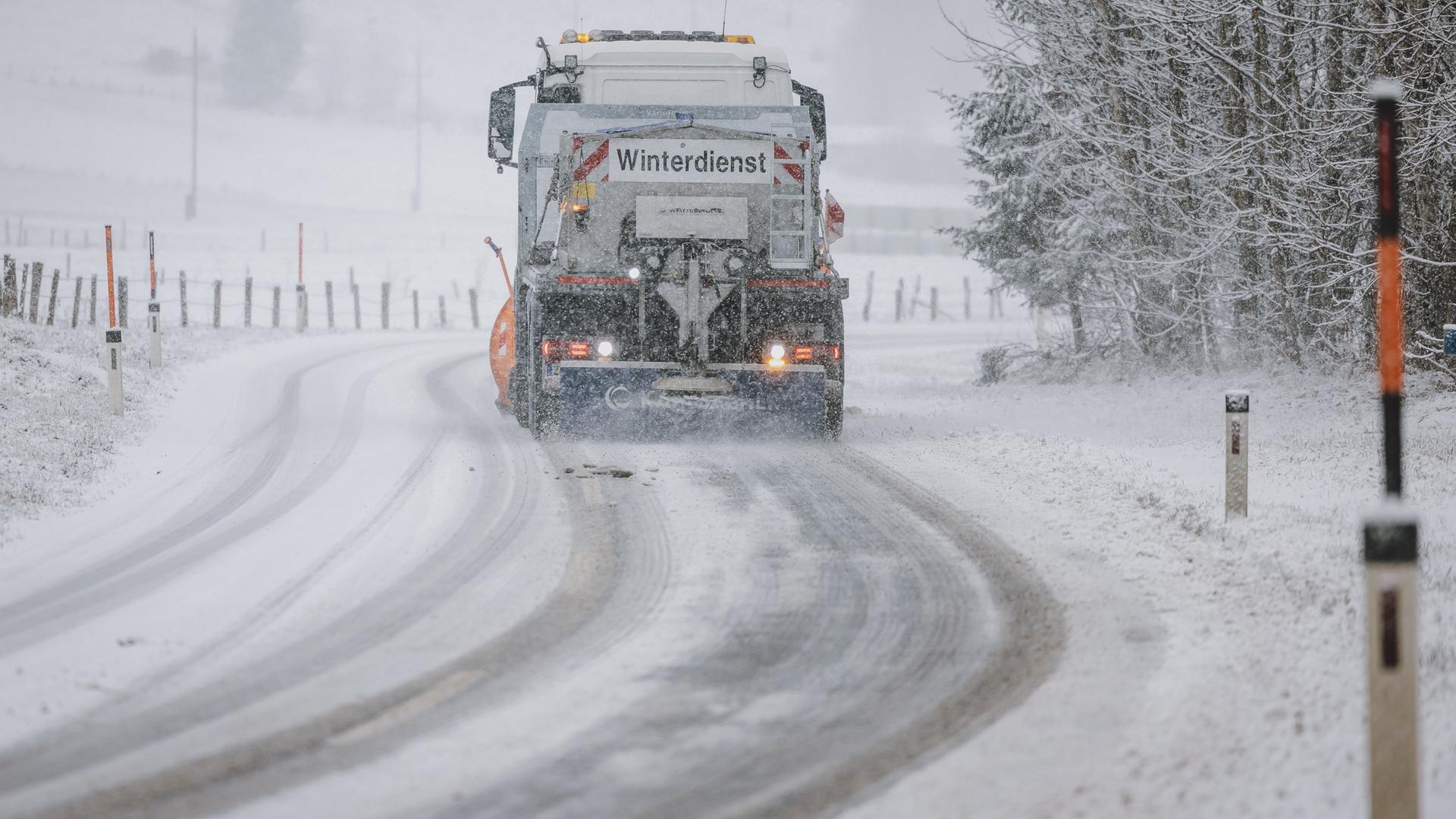 Das Bild zeigt ein Winterdienstfahrzeug bei der Räumung einer mit Schnee bedeckten Fahrbahn.