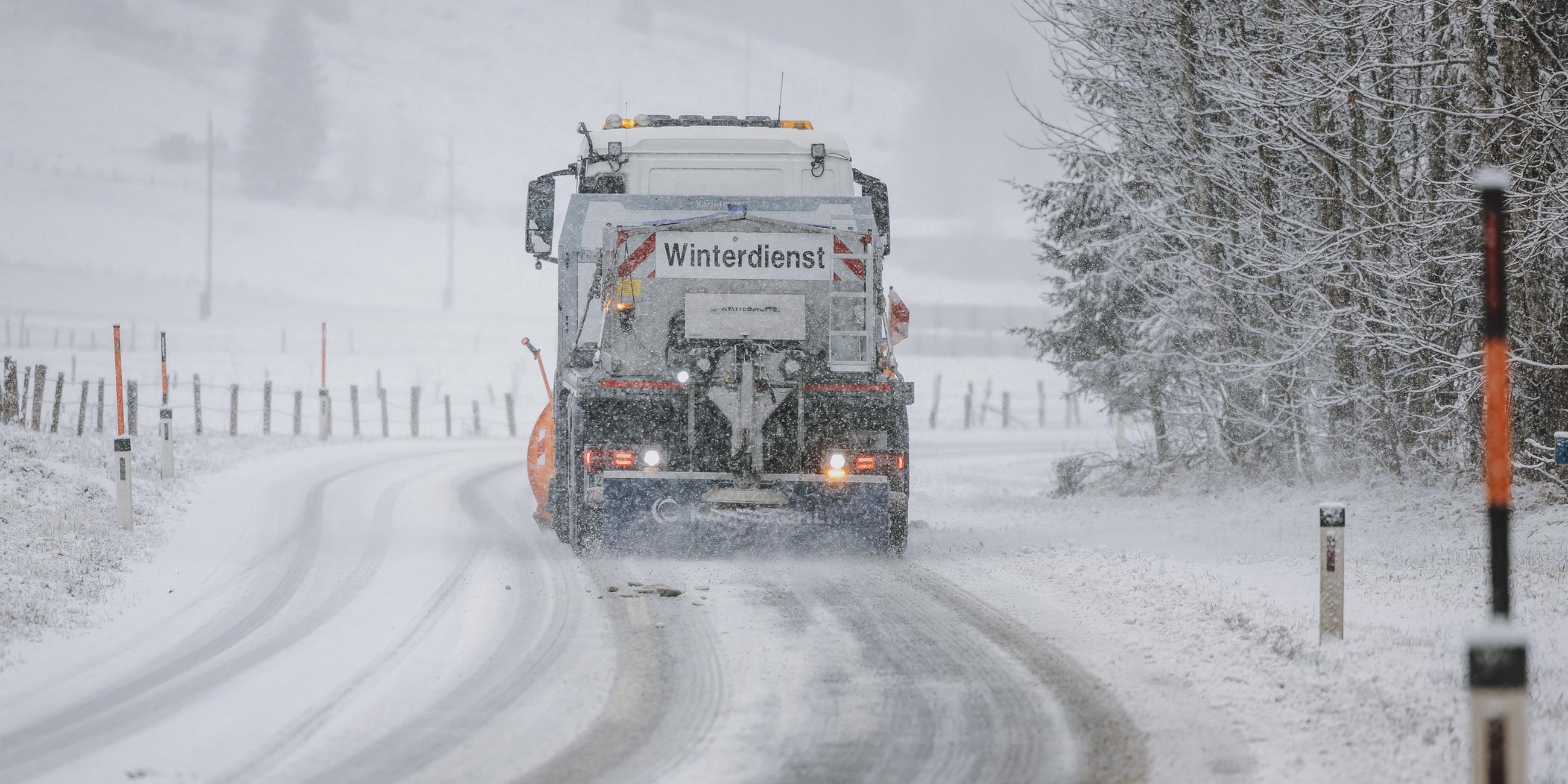 Das Bild zeigt ein Winterdienstfahrzeug bei der Räumung einer mit Schnee bedeckten Fahrbahn