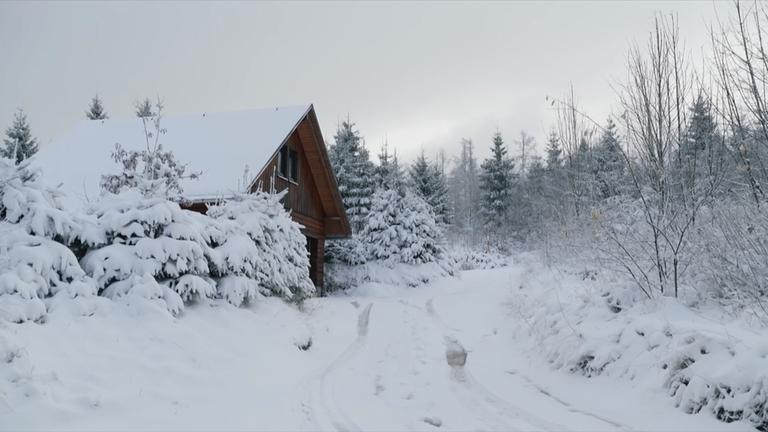 Eine Hütte in einer schneebedeckten Landschaft 