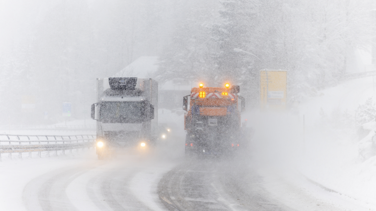 Verschneite Straße mit Fahrzeugen