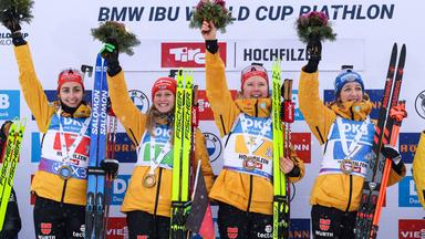 Die deutschen Biathletinnen Vanessa Voigt, Julia Tannheimer, Selina Grotian und Franziska Preuss stehen auf dem Podest und jubeln nach ihrem Sieg beim 4x6km Staffellauf.