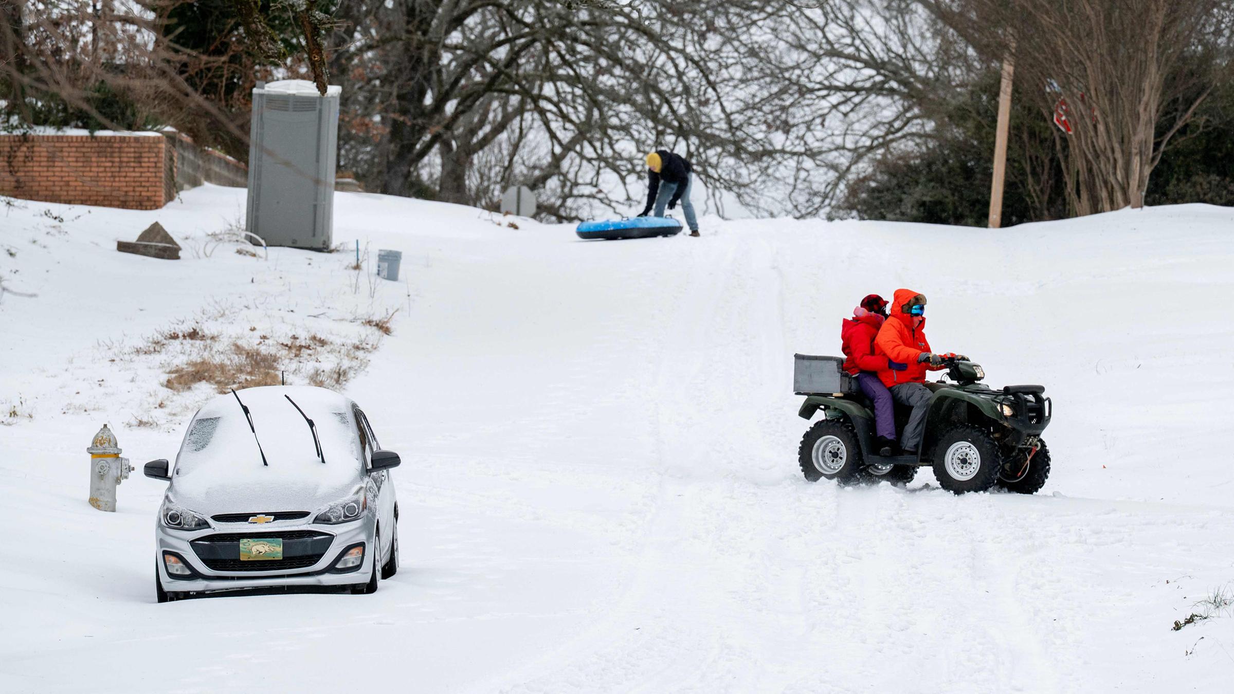 Schneebedeckte Straßen auf denen in Little Rock, Arkansas in den USA nach einem Schneesturm ein Quad durch den Schnee fährt.
