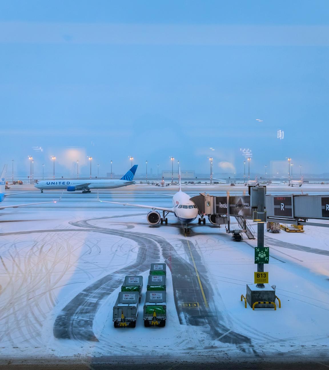 Flugzeuge am schneebedeckten Hauptstadtflughafen BER. 