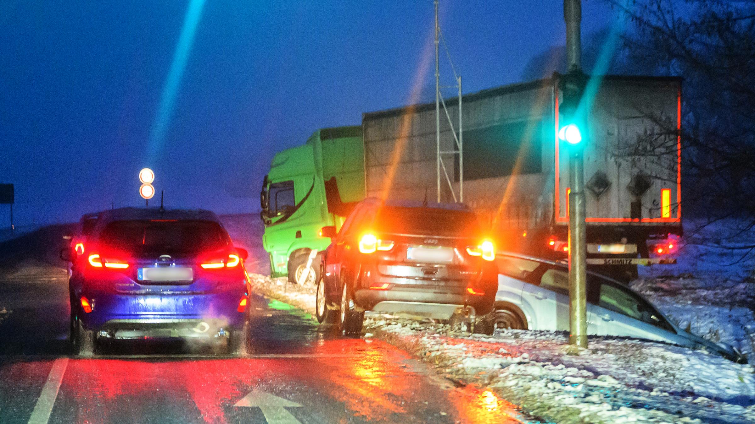 Ein Lastwagen und ein Pkw am frühen Morgen auf einer vereisten Straße von der Fahrbahn abgekommen, aufgenommen am 13.01.2026