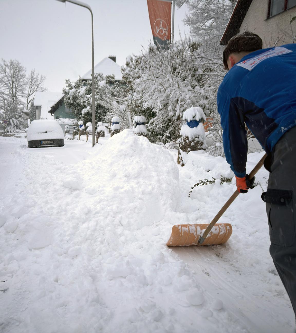 Ein Mann schaufelt im bayerischen Forchheim Schnee von einem Bürgersteig am 26.01.2026.