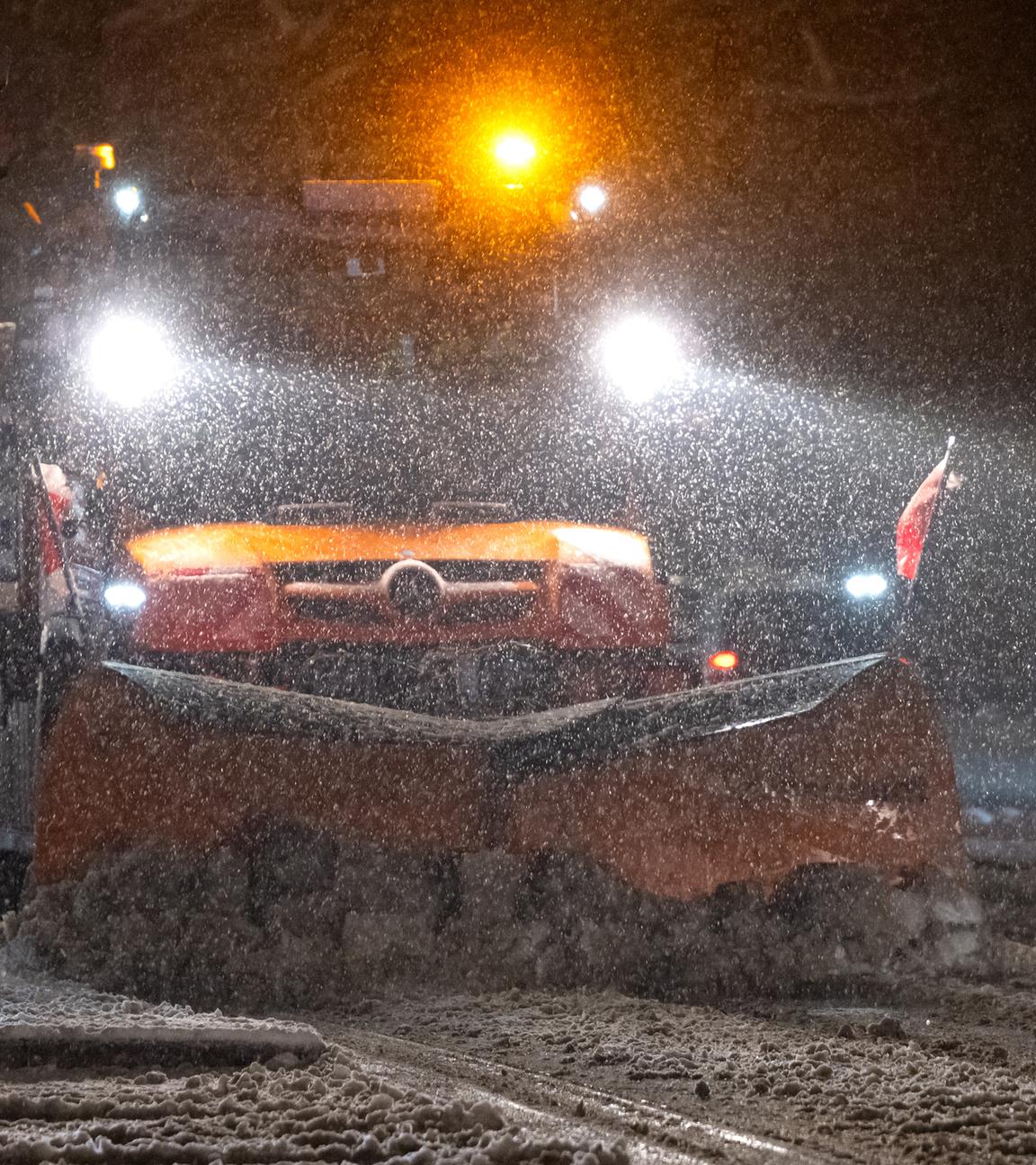 Ein Schneepflug räumt eine Straße in der Innenstadt in München