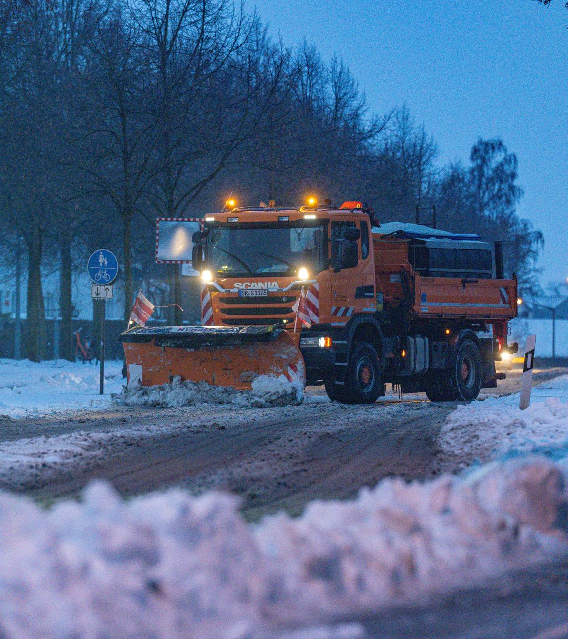 09.01.2026, Bayern, Straubing: Ein Räumfahrzeug beseitigt während Eisregens den Schnee auf einer Straße. 