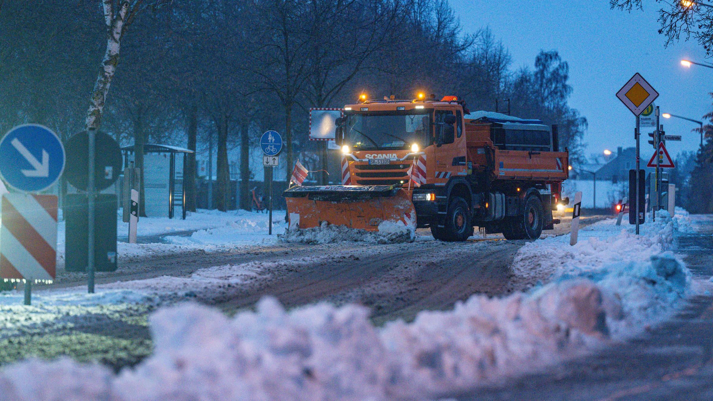 09.01.2026, Bayern, Straubing: Ein Räumfahrzeug beseitigt während Eisregens den Schnee auf einer Straße. 