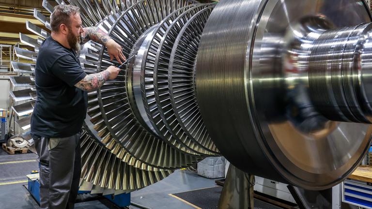 Ein Industriemechaniker arbeitet an einer Dampfturbine. 