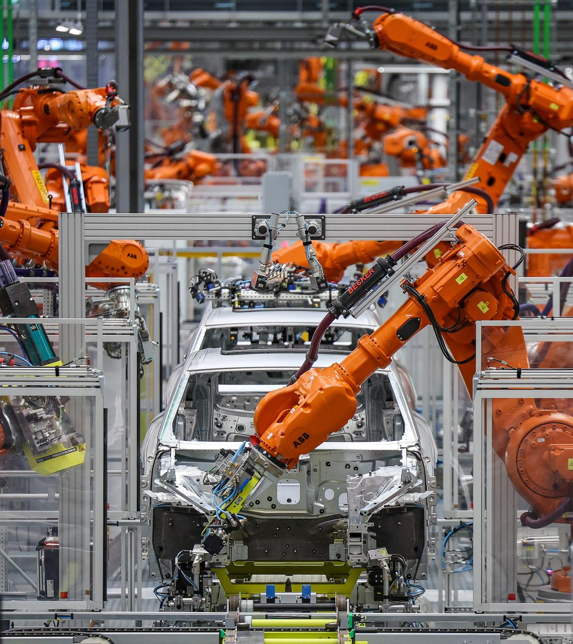 Industrieroboter arbeiten an einer Auto-Karosserie in einer Fabrik.