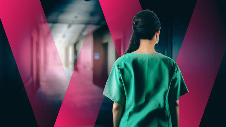 Ausländische Fachkraft steht einsam in einem Flur eines Pflegeheims