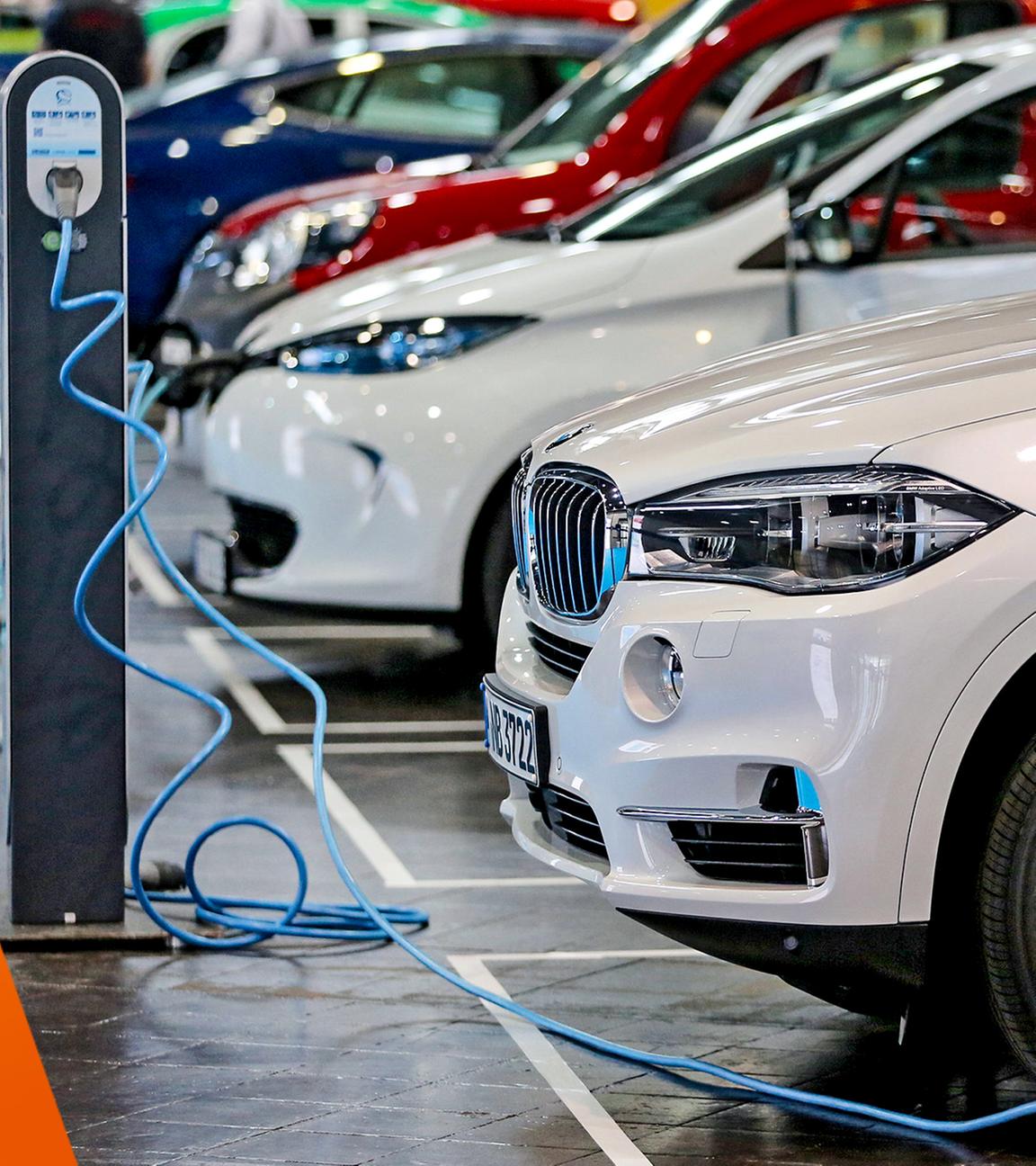 Verschiedene Elektroautos an Ladesäulen