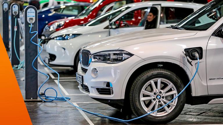 Verschiedene Elektroautos an Ladesäulen