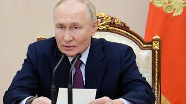 Der russische Präsident Wladimir Putin spricht in ein Mikrofon.