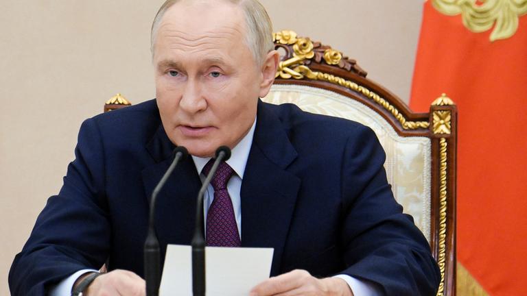 Der russische Präsident Wladimir Putin spricht in ein Mikrofon.