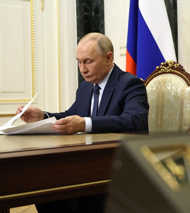 Wladimir Putin in seinem Buero während einer Videokonferenz.