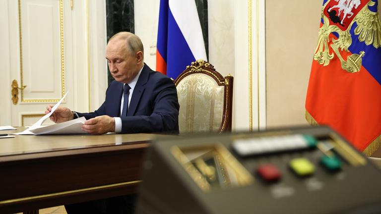 Wladimir Putin in seinem Buero während einer Videokonferenz.