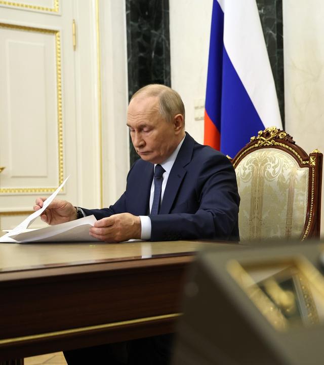 Der russische Präsident Wladimir Putin sitzt während einer Videokonferenz in seinem Büro.