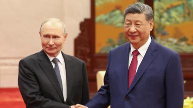 Wladimir Putin (l.), Präsident Russlands, und sein Amtskollege Xi Jinping aus China geben sich während eines informellen Teetreffens in der Großen Halle des Volkes die Hand.
