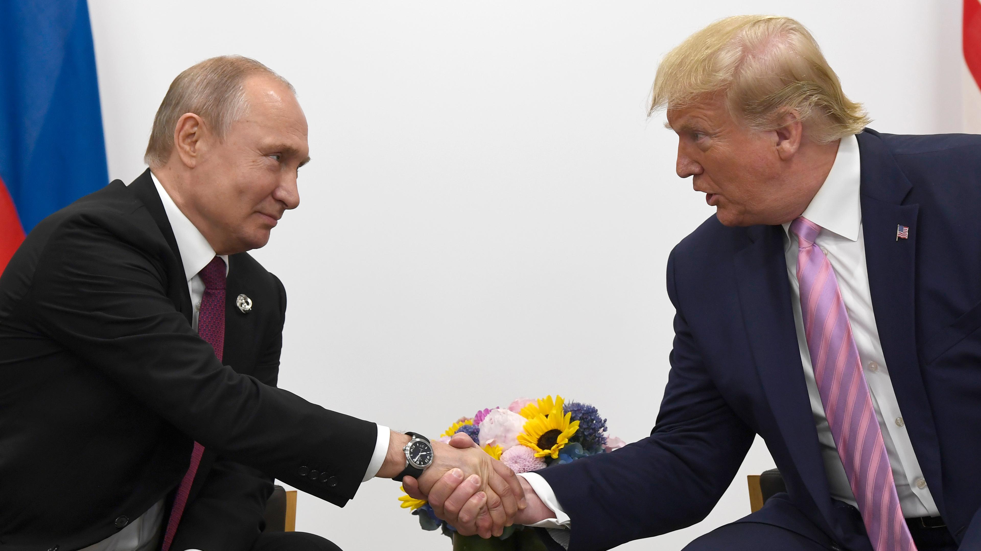 Japan, Osaka: Wladimir Putin (l), Präsident von Russland, und Donald Trump, Präsident der USA, geben sich während des G20-Gipfels die Hand. Archivbild