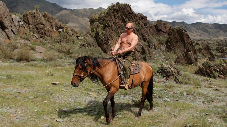 Der russische Präsident Wladimir Putin reitet mit freiem Oberkörper durch die Berge Sibiriens.