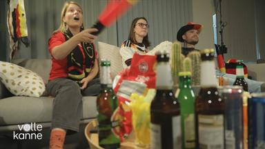 Feiernde Fußball-Fans auf der Couch.