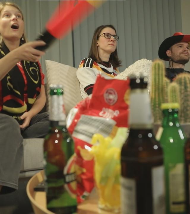 Feiernde Fußball-Fans auf der Couch.
